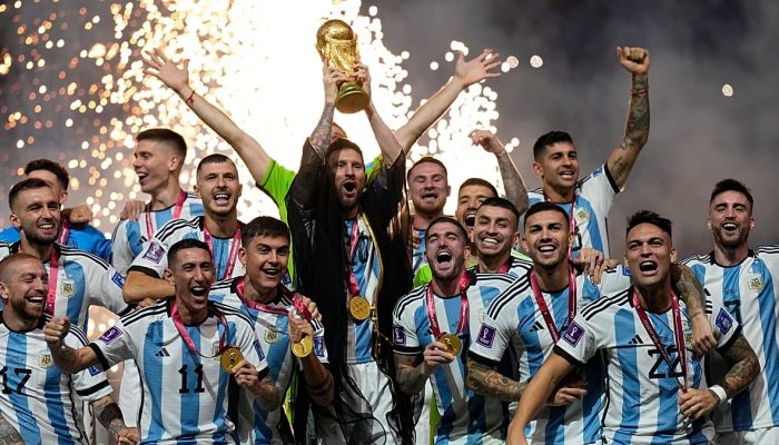 Lionel Messi, da Argentina, beija o troféu entregue pelo presidente da FIFA, Gianni Infantino (à esquerda), sob o olhar do emir do Qatar, xeque Tamim bin Hamad Al Thani Copyright 2