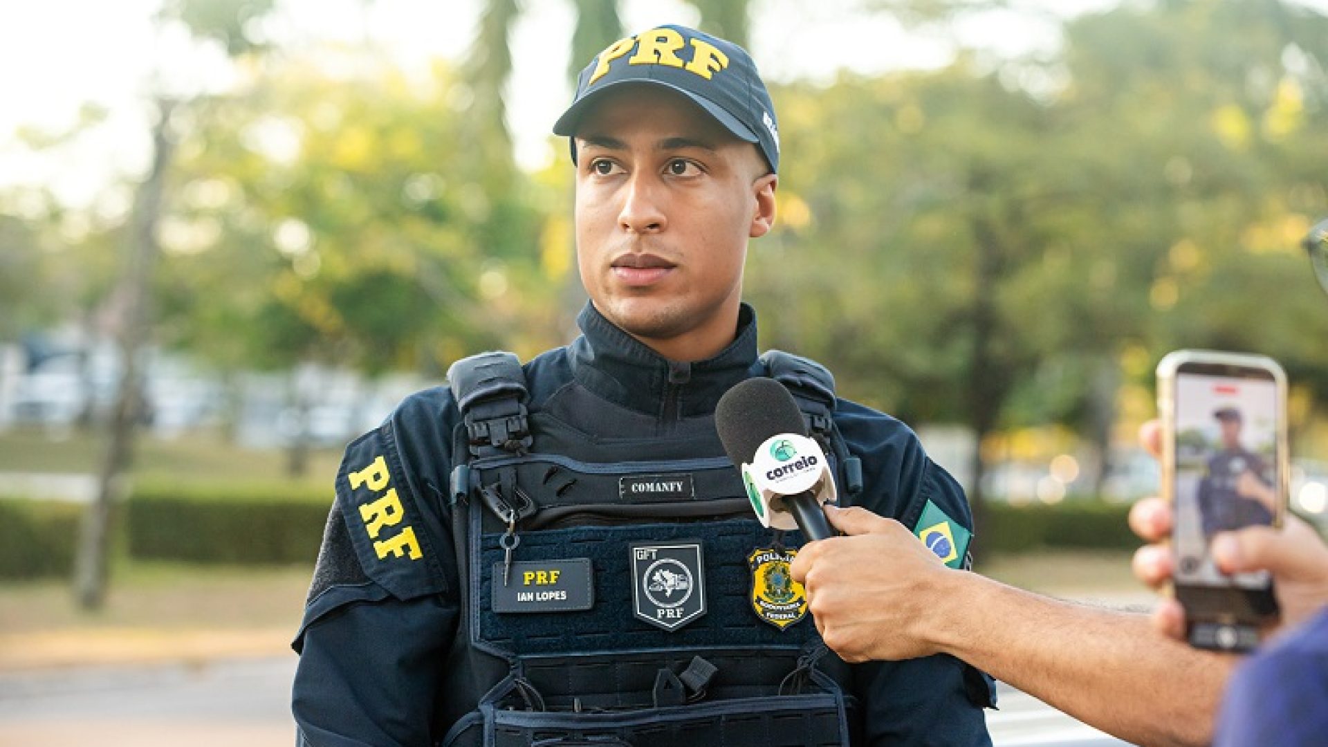 Agente Ian explica que orienta os motoristas a esperarem no pátio da loja Havan, onde há mais espaço