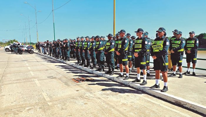 Linha de policiais militares brasileiros em formação de prontidão ao ar livre
